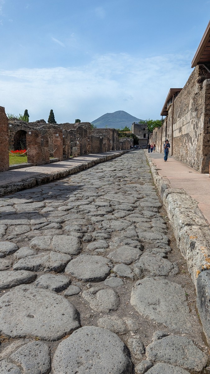 A Pompeii street with Mount Vesuvius in the background.